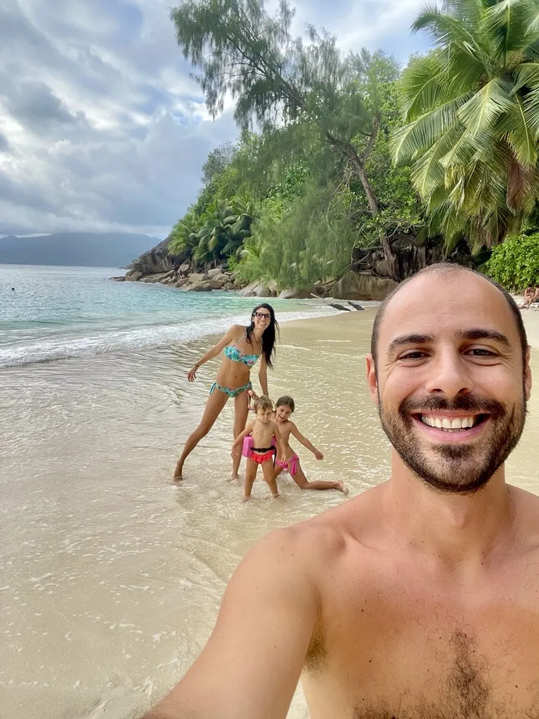 Famiglia su una spiaggia tropicale a Mahé Seychelles con graniti e palme